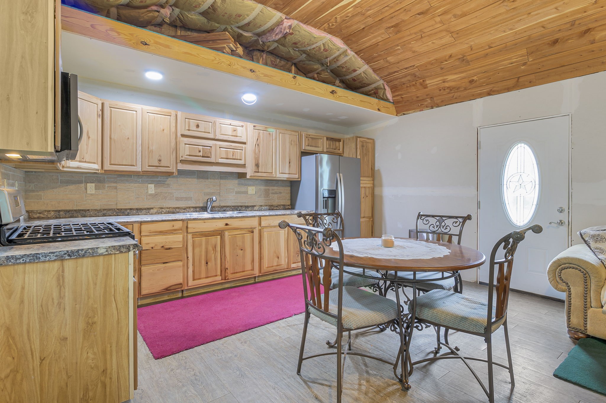 300 Collier Road Point Blank, TX 77364 - Photo 21 of 49 a kitchen with stainless steel appliances kitchen island granite countertop a dining table chairs and granite counter tops
