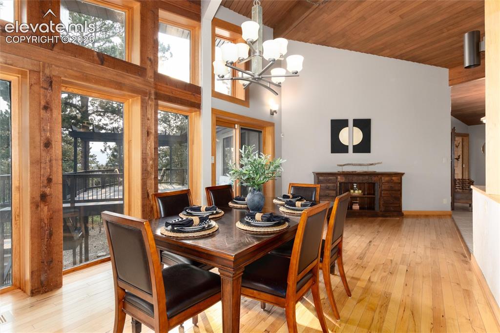 12730 Bridle Bit Road Colorado Springs, CO 80908 - Photo 10 of 50 Dining area featuring natural wood-finish flooring and a wood-paneled vaulted ceiling