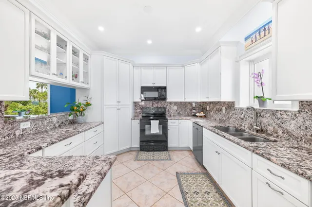 a kitchen with granite countertop a sink stove top oven and cabinets