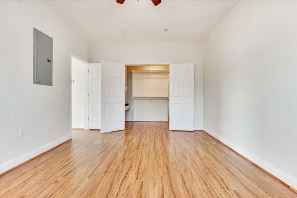 a view of an empty room with wooden floor and a window