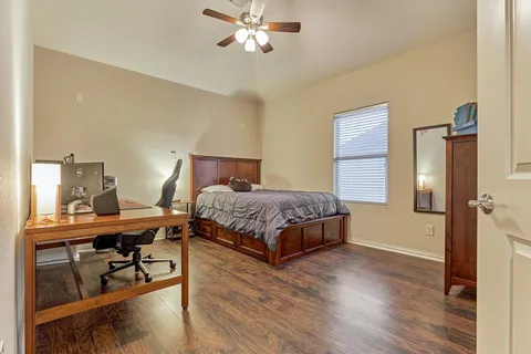 a bedroom with a bed table and a chandelier