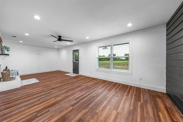 a view of a room with wooden floor and window