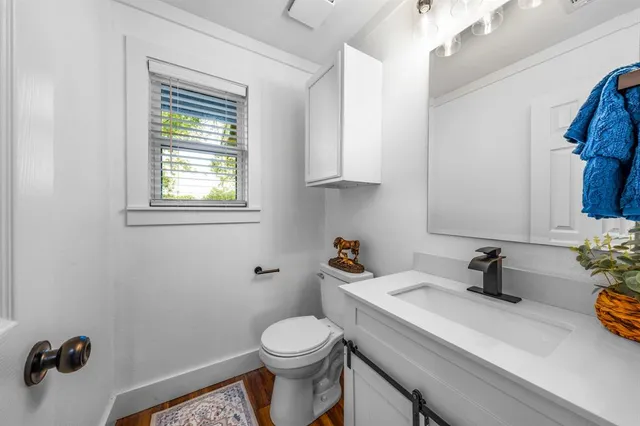 a bathroom with a sink a toilet and a mirror