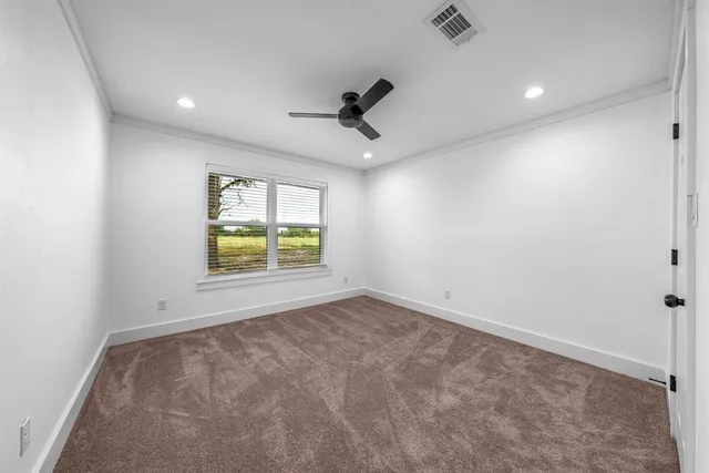 an empty room with windows and fan