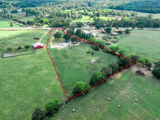 an aerial view of residential houses with outdoor space and trees