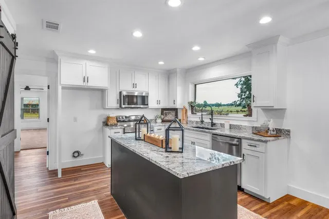 a kitchen with stainless steel appliances granite countertop a sink stove and refrigerator