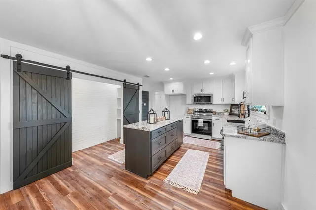 a large kitchen with a large counter top appliances and cabinets