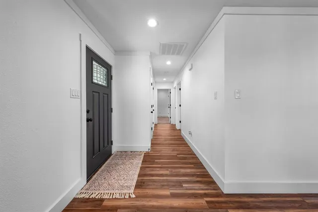 a view of a hallway with wooden floor and staircase