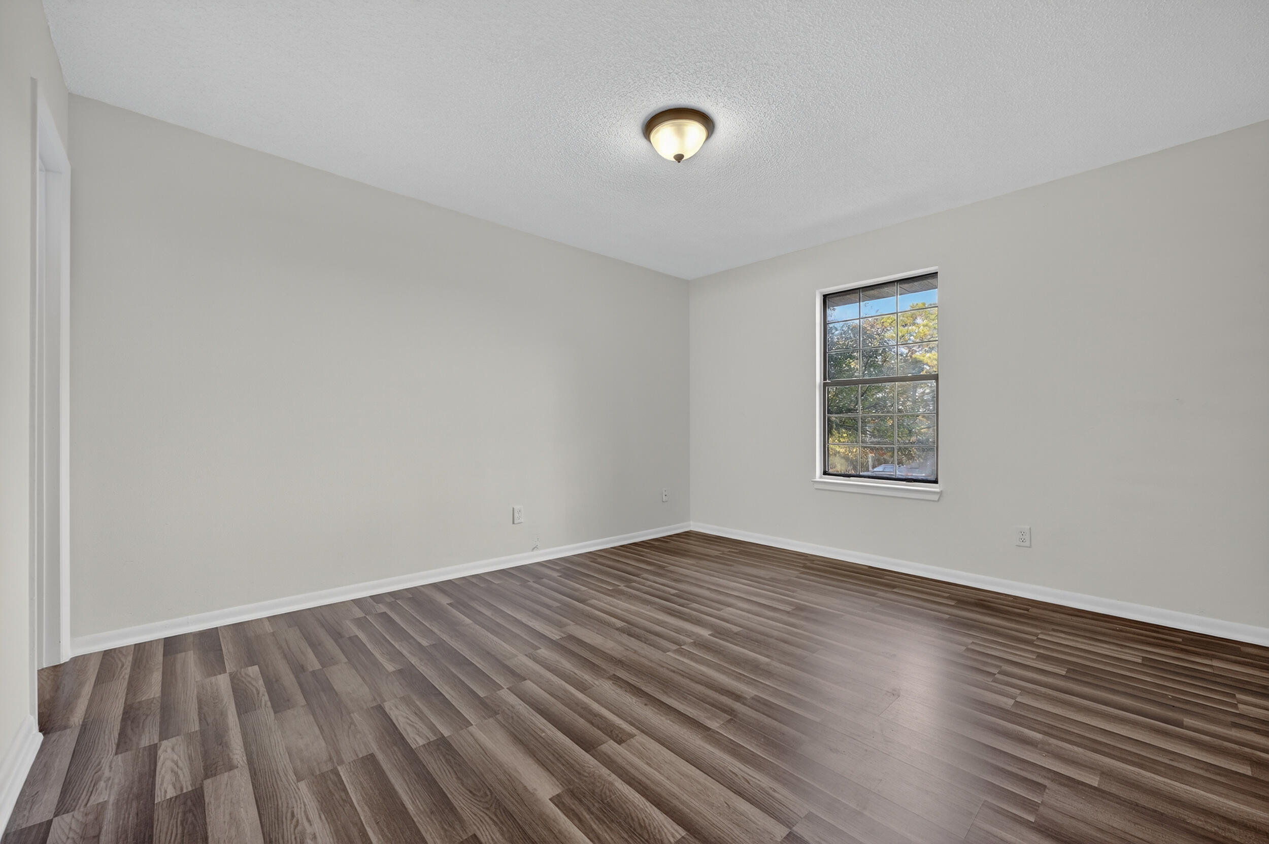 552 Roberts Drive DeFuniak Springs, FL 32433 - Photo 21 of 40 an empty room with wooden floor and windows