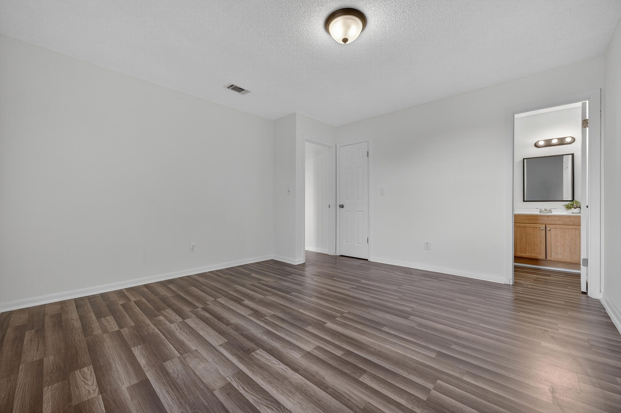 552 Roberts Drive DeFuniak Springs, FL 32433 - Photo 23 of 40 an empty room with wooden floor and mirror