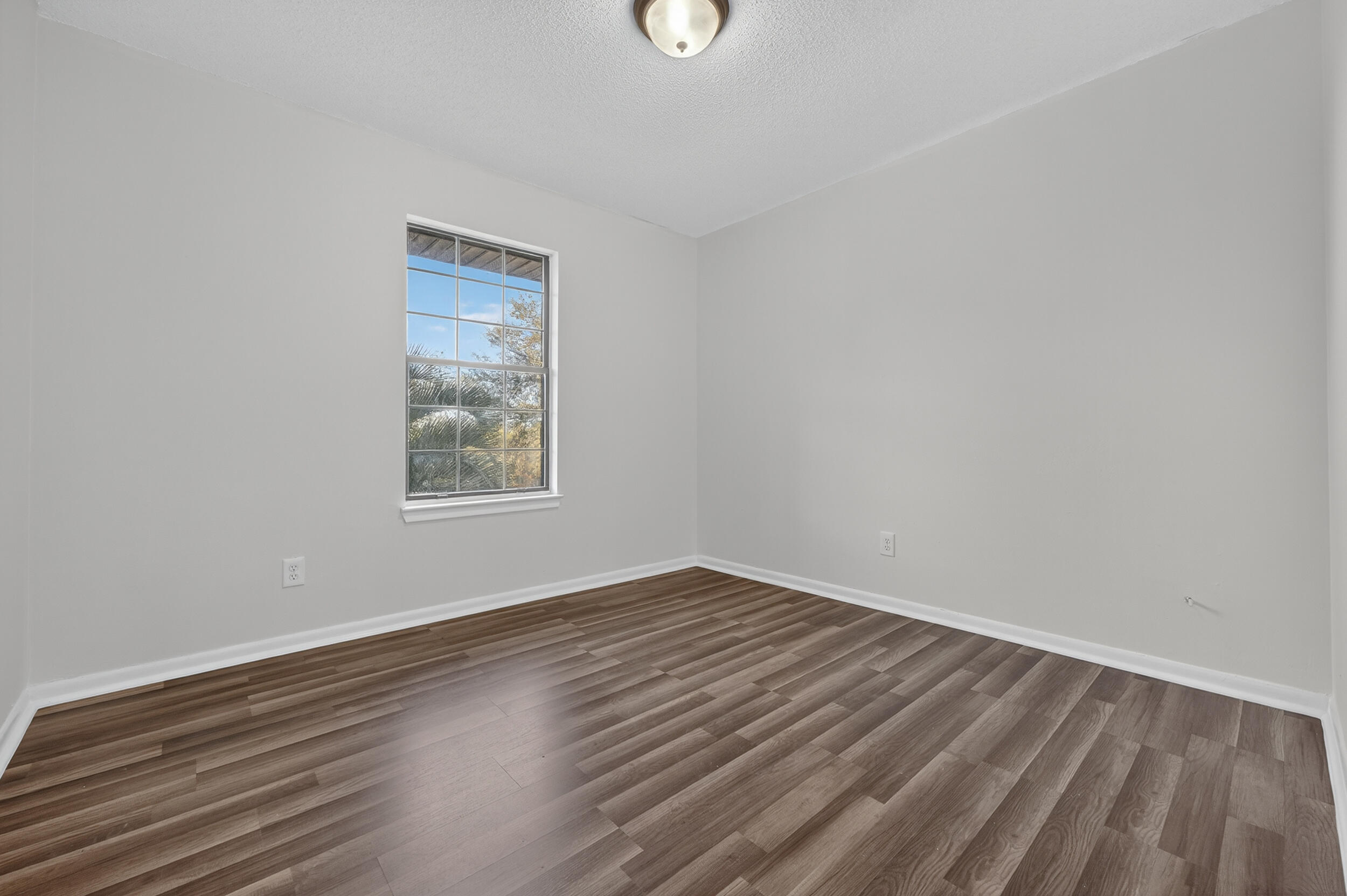 552 Roberts Drive DeFuniak Springs, FL 32433 - Photo 27 of 40 a view of an empty room with wooden floor and a window