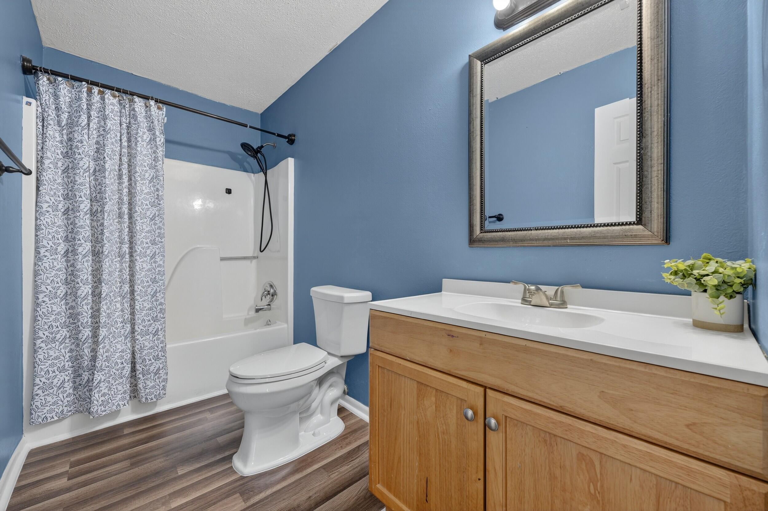 552 Roberts Drive DeFuniak Springs, FL 32433 - Photo 29 of 40 a bathroom with a granite countertop sink toilet mirror and shower
