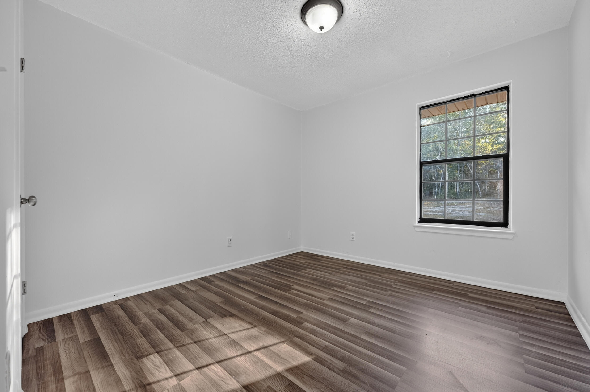 552 Roberts Drive DeFuniak Springs, FL 32433 - Photo 31 of 40 an empty room with wooden floor and windows