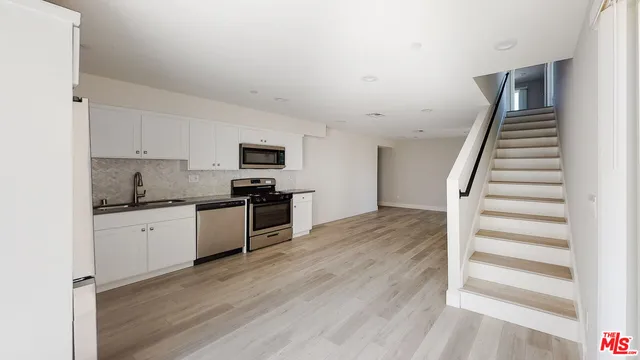 a kitchen with granite countertop white cabinets and appliances