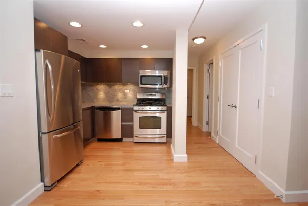 a kitchen with stainless steel appliances a refrigerator and a stove top oven
