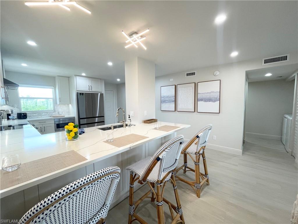12945 Vanderbilt Drive, Unit 403 Naples, FL 34110 - Photo 11 of 42 a view of a dining area with furniture and a chandelier