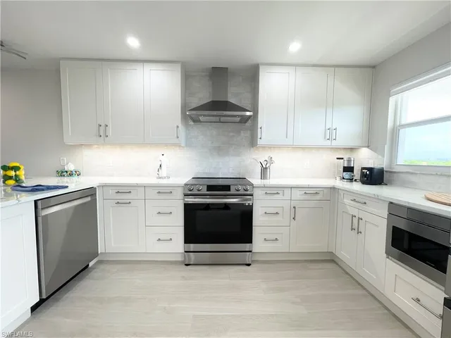 a kitchen with granite countertop white cabinets and white appliances