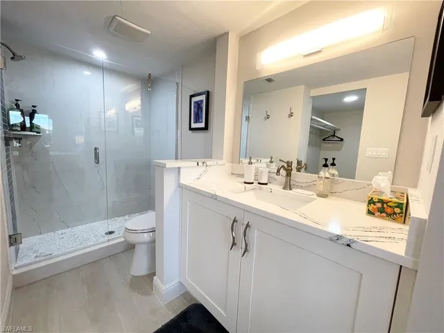 a bathroom with a sink a toilet a shower and a mirror