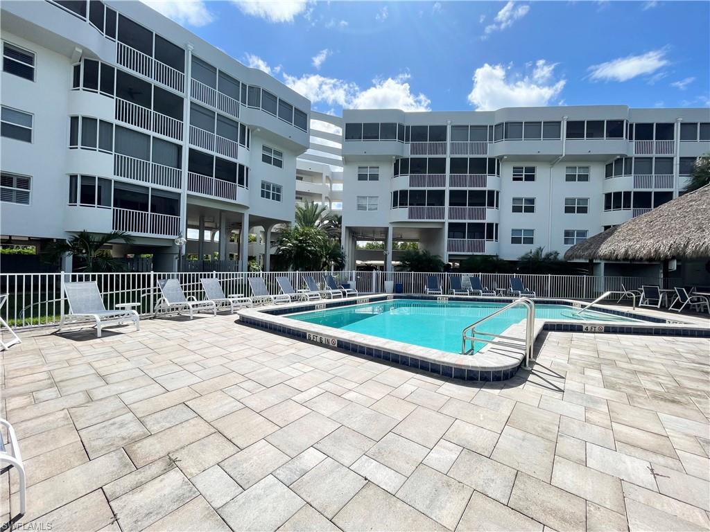 12945 Vanderbilt Drive, Unit 403 Naples, FL 34110 - Photo 34 of 42 a view of a swimming pool with a lounge chairs