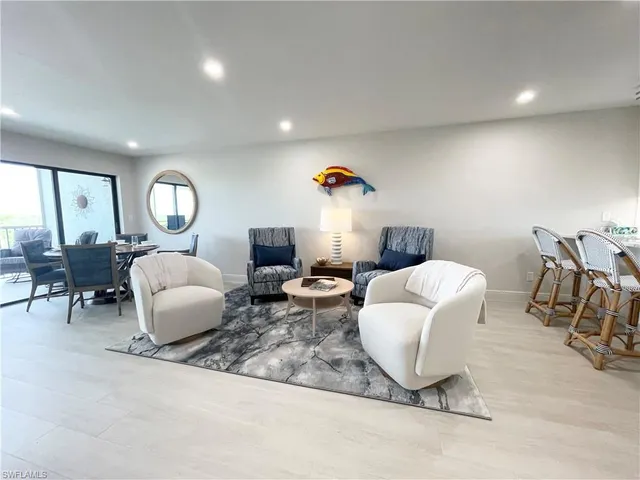 a living room with furniture a lamp and a large window