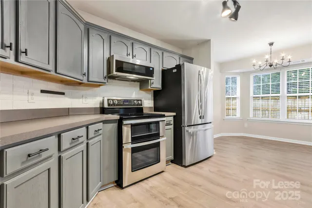 a kitchen with stainless steel appliances a refrigerator stove and microwave