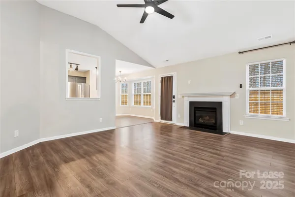 wooden floor fireplace and windows in an empty room