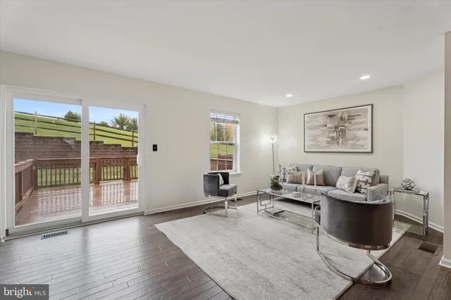 a living room with furniture a wooden floor and next to a window