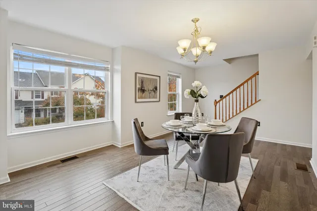 a view of a dining room with furniture a chandelier and wooden floor