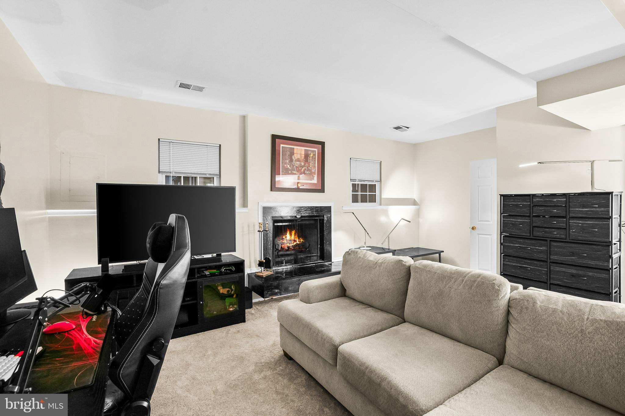 2418 Ridgehampton Court Reston, VA 20191 - Photo 22 of 28 a living room with furniture a flat screen tv and a fireplace