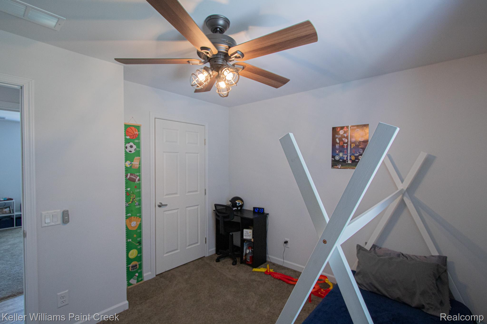 5200 Babcock Road Lexington, MI 48450 - Photo 22 of 31 Overhead ceiling fan with wood-finish blades and caged light fixtures