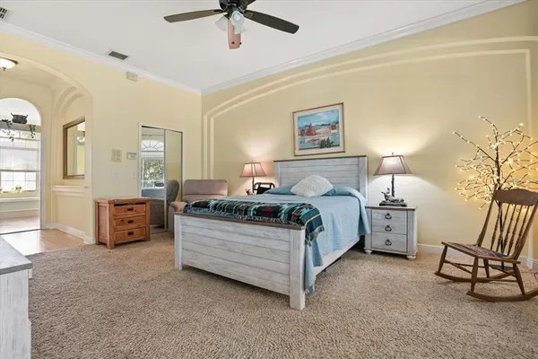 a spacious bedroom with a bed and wooden floor