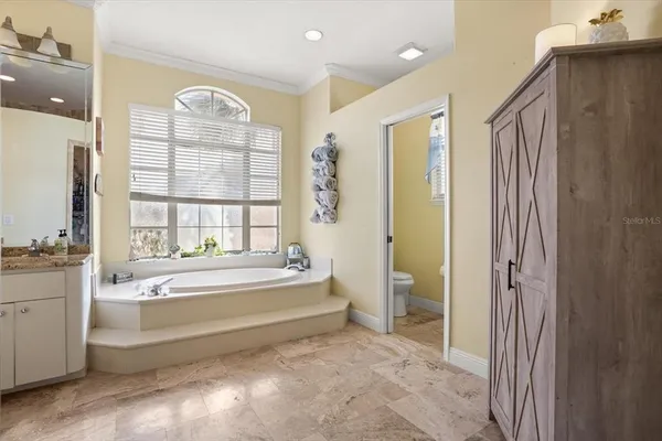 a large bathroom with a granite countertop sink a toilet a large mirror and shower