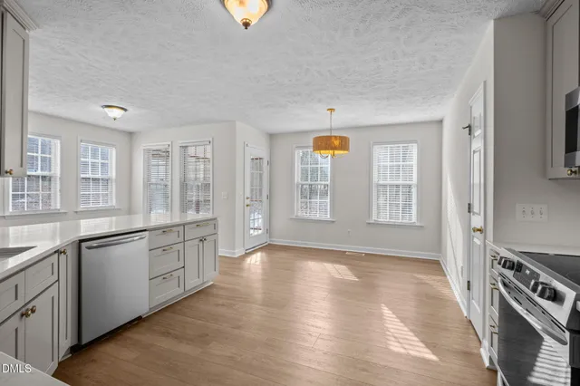 a kitchen with granite countertop a stove a sink and a refrigerator