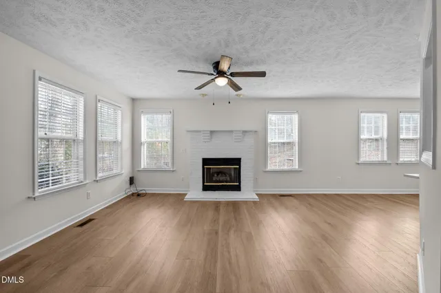 a view of an empty room with a fireplace and a window