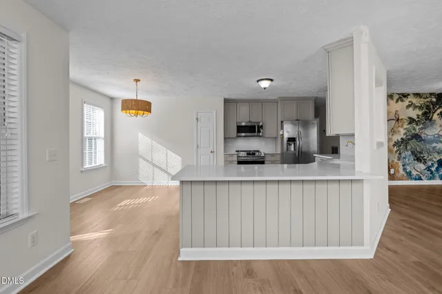 a kitchen with stainless steel appliances a refrigerator and a stove top oven