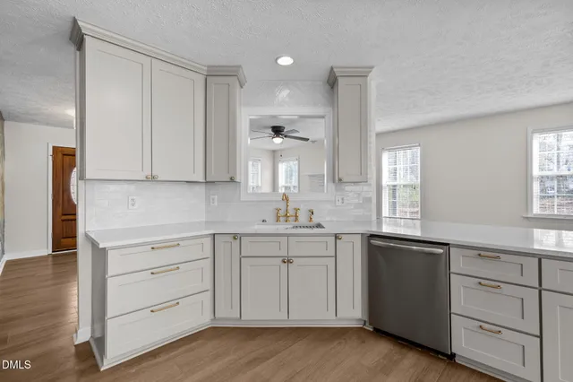 a kitchen with white cabinets and sink