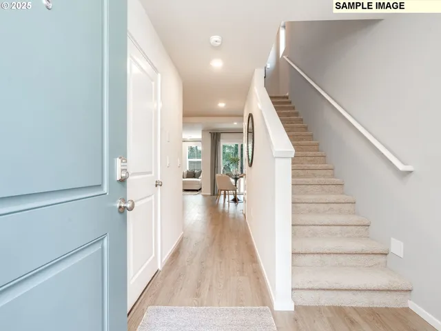 a view of a hallway with wooden floor and staircase