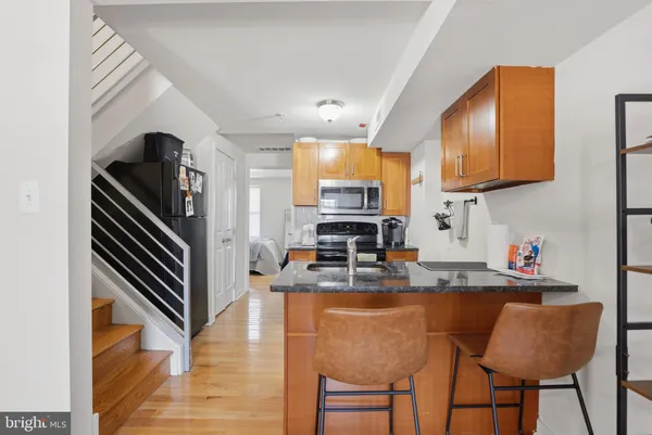 a kitchen with granite countertop a refrigerator stove top oven and sink