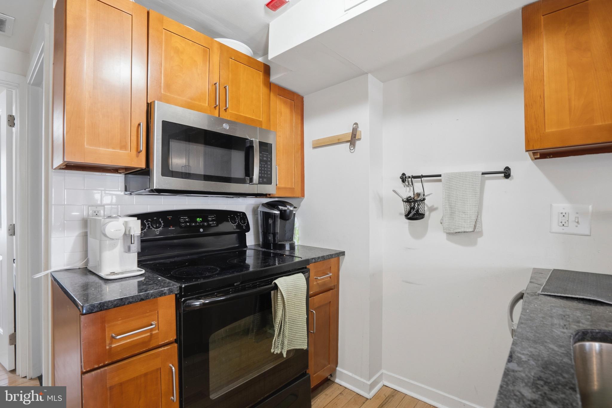 520 South 4th Street, Unit C Philadelphia, PA 19147 - Photo 7 of 18 a kitchen with stainless steel appliances granite countertop a stove microwave and sink