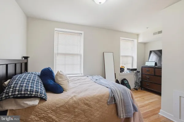 a bedroom with a bed and dresser with mirror