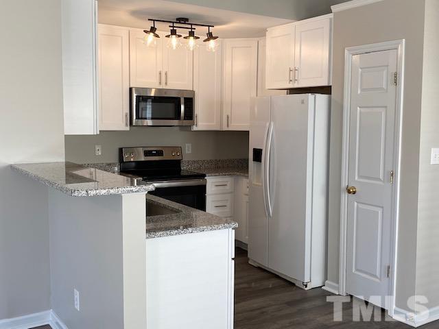 506 Homestead Park Drive Apex, NC 27502 - Photo 4 of 18 a kitchen with granite countertop a refrigerator and a stove top oven