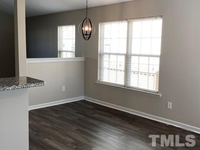 506 Homestead Park Drive Apex, NC 27502 - Photo 5 of 18 an empty room with wooden floor fan and windows