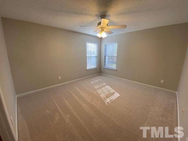 506 Homestead Park Drive Apex, NC 27502 - Photo 8 of 18 en empty room with windows and chandelier fan