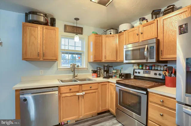 a kitchen with stainless steel appliances granite countertop a sink stove and microwave