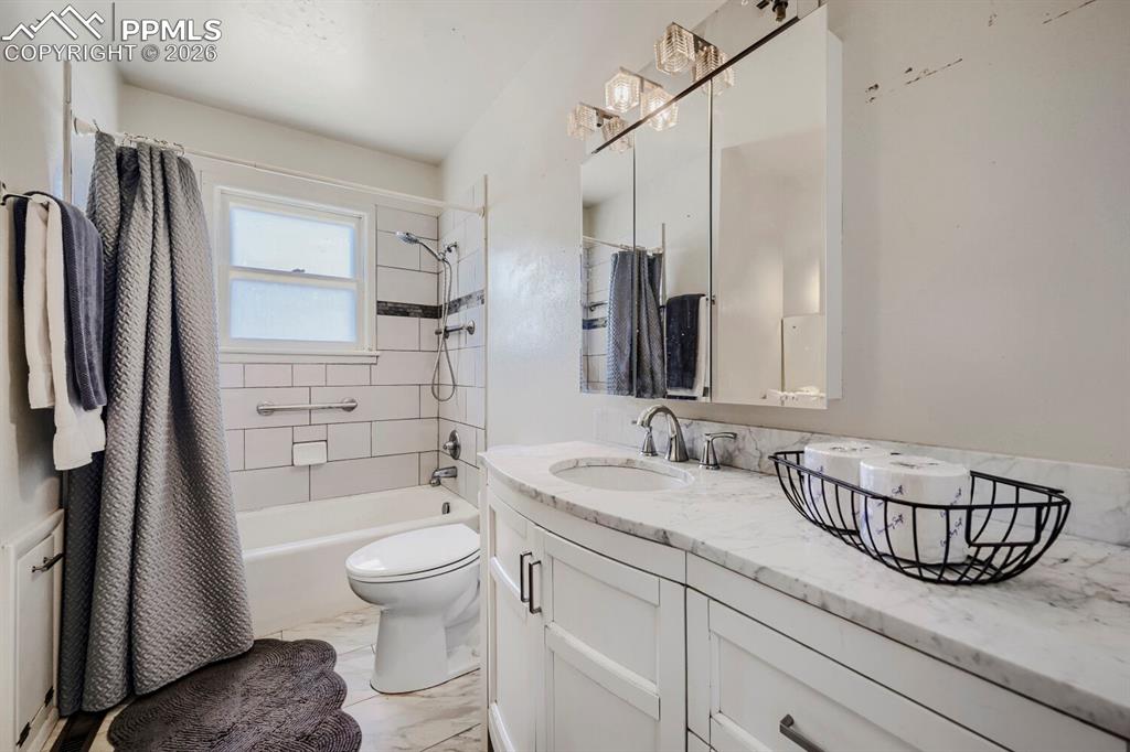 2898 Merry Lane Colorado Springs, CO 80909 - Photo 11 of 19 a bathroom with a granite countertop sink a toilet and shower
