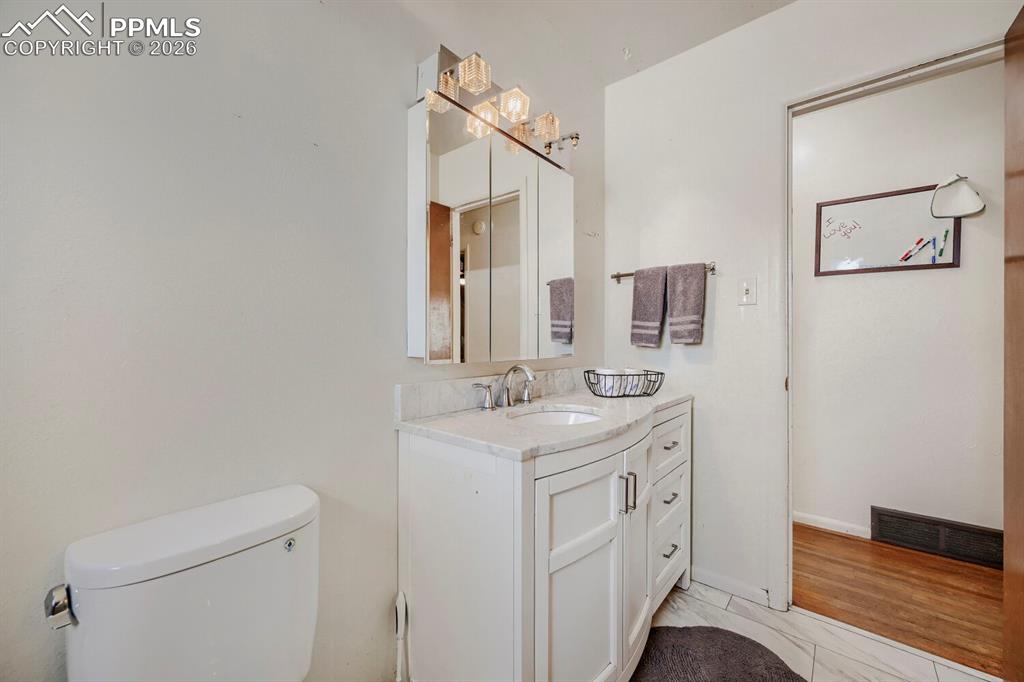2898 Merry Lane Colorado Springs, CO 80909 - Photo 12 of 19 a bathroom with a sink a toilet and mirror