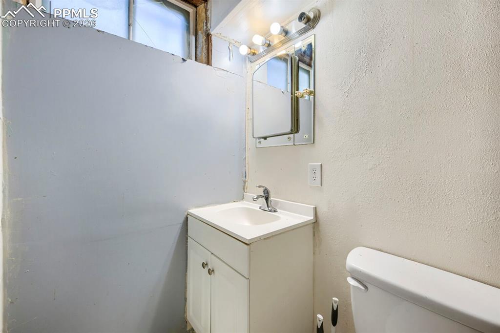 2898 Merry Lane Colorado Springs, CO 80909 - Photo 13 of 19 a bathroom with a toilet sink and mirror