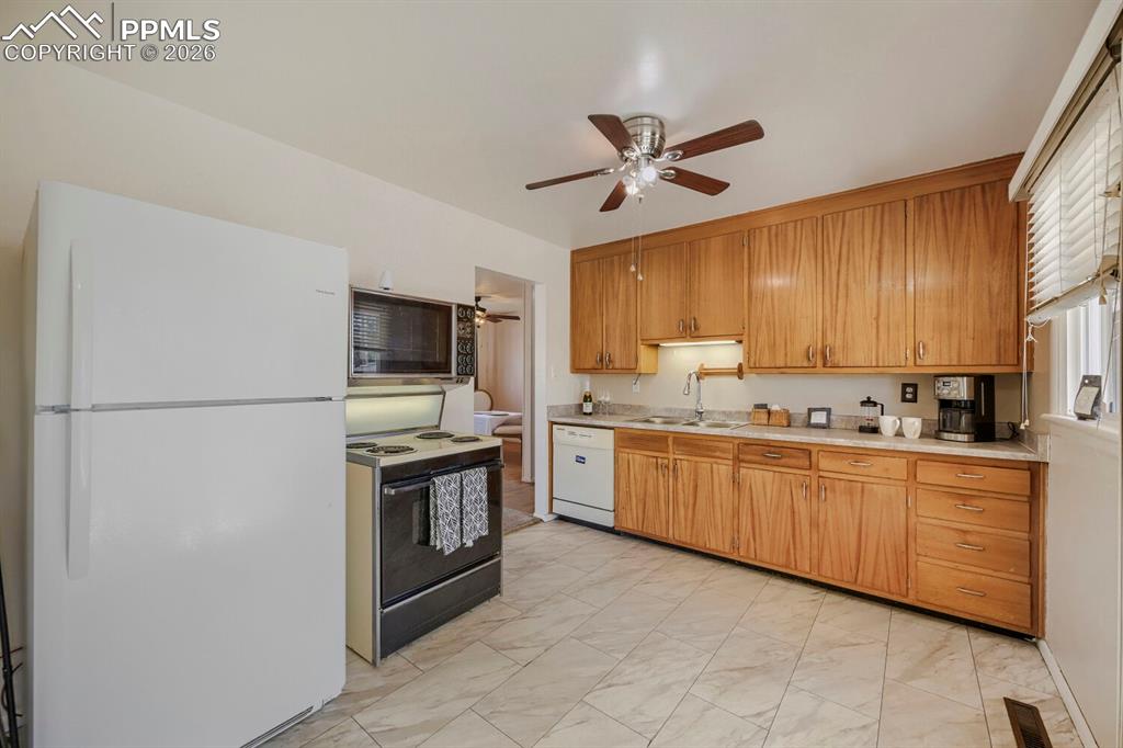 2898 Merry Lane Colorado Springs, CO 80909 - Photo 4 of 19 a kitchen with granite countertop stainless steel appliances and wooden cabinets