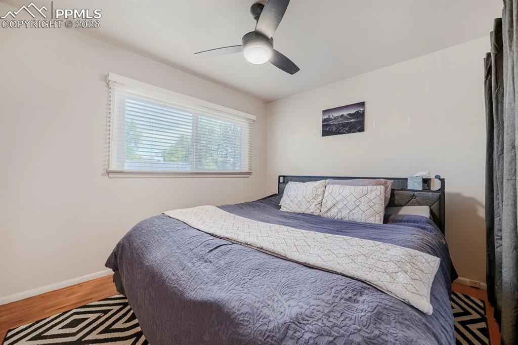 2898 Merry Lane Colorado Springs, CO 80909 - Photo 7 of 19 a bedroom with a large bed and a chandelier