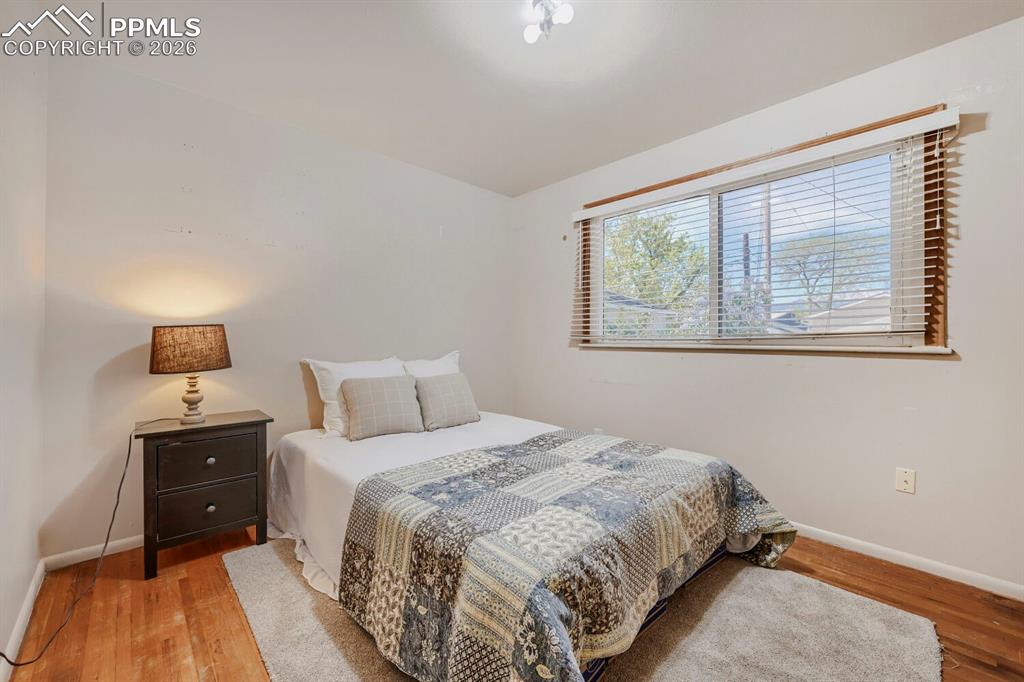 2898 Merry Lane Colorado Springs, CO 80909 - Photo 9 of 19 a bedroom with a bed and a lamp